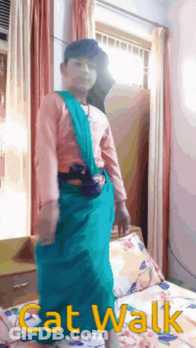 A Boy In A Cat Walk Costume Is Standing In Front Of A Window GIF