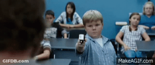 A Boy In A Classroom Is Pointing A Gun At Someone GIF