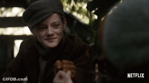 A Boy In A Hat Is Smiling In A Netflix Advertisement GIF