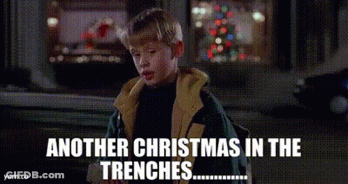 A Boy In A Jacket Is Standing In Front Of A Christmas Tree And Says Another Christmas In The Trenches . GIF