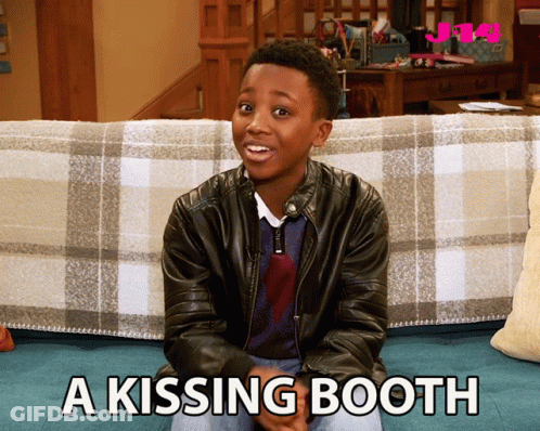 A Boy In A Leather Jacket Sits On A Couch With The Words A Kissing Booth Written Below Him GIF