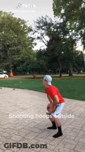 A Boy In A Red Shirt Is Playing Basketball Outside GIF
