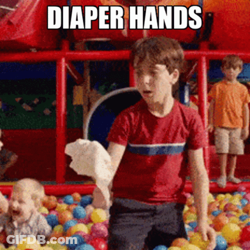 A Boy In A Red Shirt Is Standing In A Ball Pit With Diaper Hands Written On The Bottom GIF