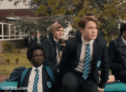 A Boy In A School Uniform Has The Letter T On His Collar GIF