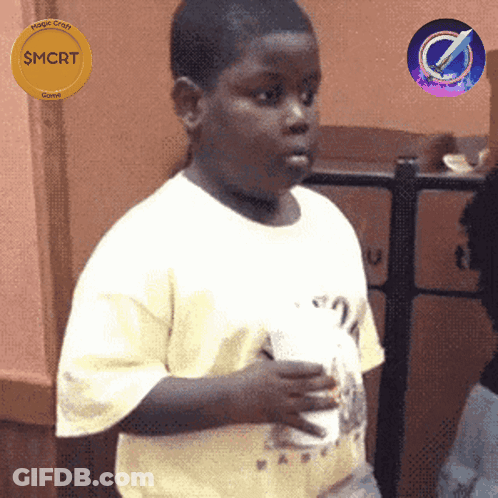 A Boy In A White Shirt Is Holding A Cup And A Gold Coin That Says Smcrt GIF