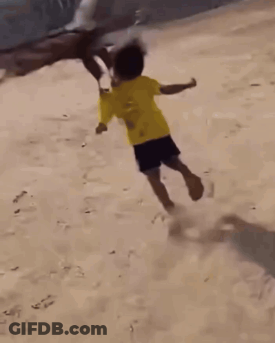 A Boy In A Yellow Shirt Is Being Attacked By A Bird GIF