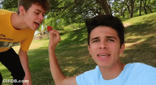A Boy In A Yellow Shirt Is Eating A Strawberry GIF