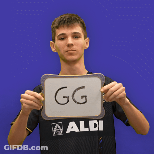 A Boy In An Aldi Shirt Holds Up A Sign That Says Ez GIF