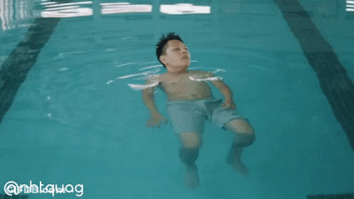 A Boy Is Floating In A Swimming Pool With The Hashtag @Nhtquag GIF