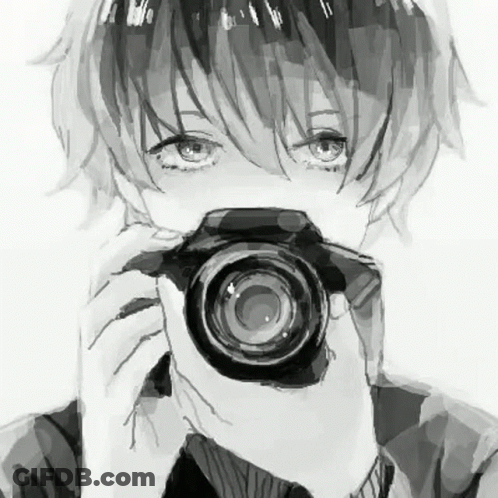 A Boy Is Holding A Camera In Front Of His Face . GIF