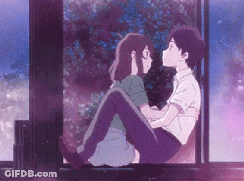 A Boy Is Holding A Girl In His Arms While They Are Sitting On A Window Sill . GIF