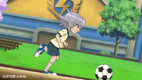 A Boy Is Kicking A Soccer Ball On A Field GIF