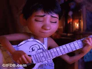 A Boy Is Playing A Guitar With His Eyes Closed GIF