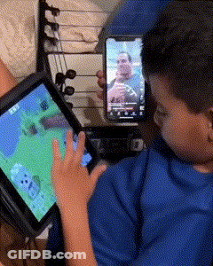 A Boy Is Playing A Video Game On A Tablet GIF