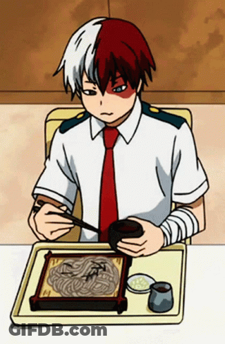 A Boy Is Sitting At A Table Eating Noodles With Chopsticks . GIF