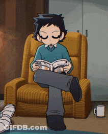 A Boy Is Sitting In A Chair Reading A Magazine GIF