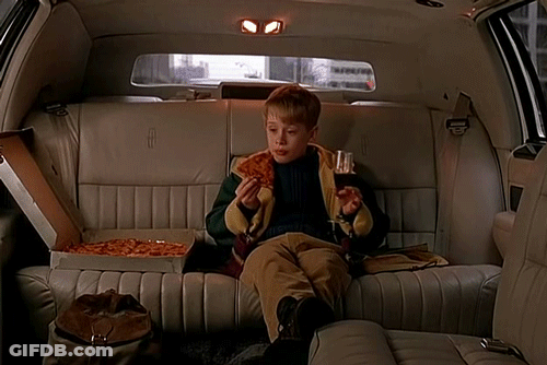 A Boy Is Sitting In The Back Seat Of A Lincoln Limousine Eating Pizza GIF