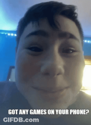 A Boy Is Smiling With The Words Got Any Games On Your Phone Below His Face GIF