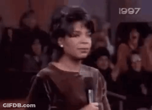 A Boy Is Standing In Front Of A Crowd With His Mouth Open . GIF