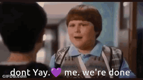 A Boy Is Talking To Another Boy In A Hallway While Holding A Purple Heart . GIF