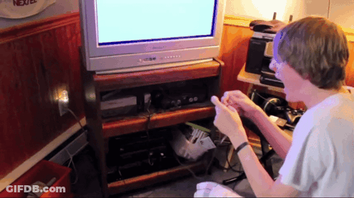 A Boy Playing A Video Game In Front Of A Tv That Says Nextel On It GIF