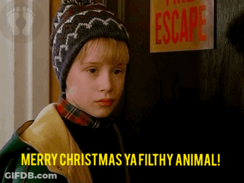 A Boy Says Merry Christmas Ya Filthy Animal In Front Of A Sign That Says Escape GIF