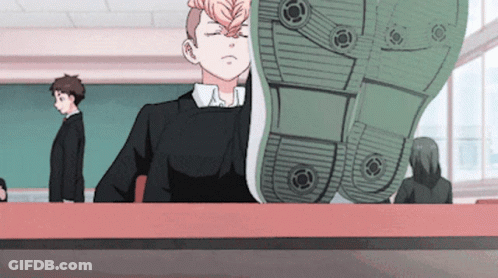 A Boy Sitting At A Desk With His Eyes Closed And A Shoe On His Head GIF