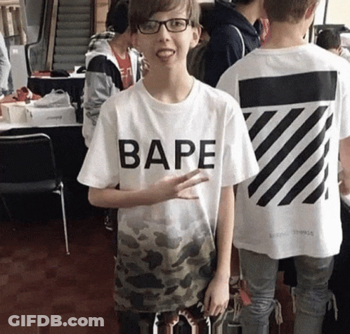 A Boy Wearing A Bape T-Shirt Stands In A Crowd Of People GIF