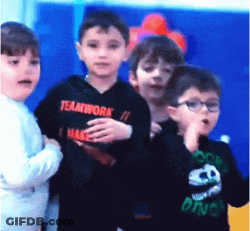 A Boy Wearing A Black Teamwork Shirt Stands In A Line With Other Children GIF