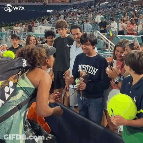 A Boy Wearing A Boston Sweatshirt Is Surrounded By People GIF