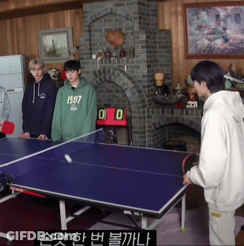 A Boy Wearing A Green 1987 Sweatshirt Is Playing Ping Pong With Two Other Boys GIF