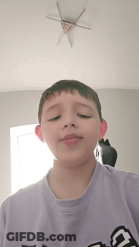 A Boy Wearing A Purple Shirt With The Letter G On It GIF