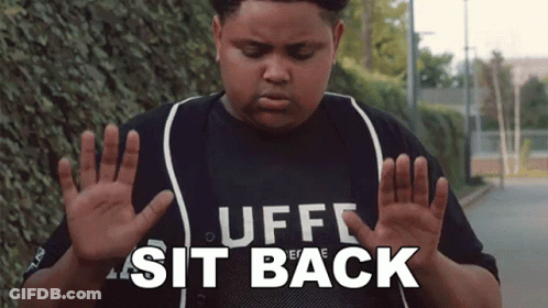 A Boy Wearing A Shirt That Says " Uff Sit Back " GIF