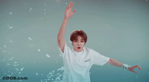 A Boy Wearing A White Shirt That Says Balenciaga Is Jumping In The Air GIF