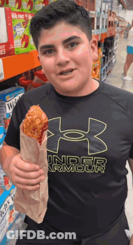 A Boy Wearing An Under Armour Shirt Is Holding A Fried Chicken GIF