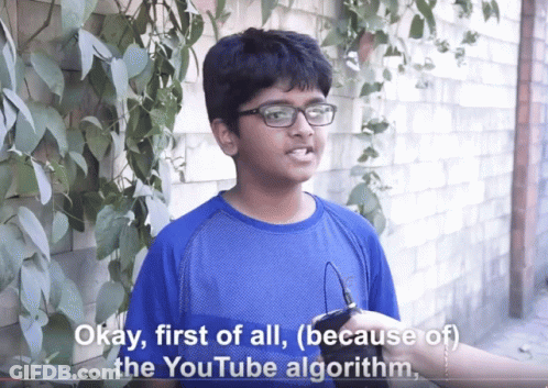 A Boy Wearing Glasses And A Blue Shirt Says Okay First Of All ( Because Of The Youtube Algorithm ) GIF