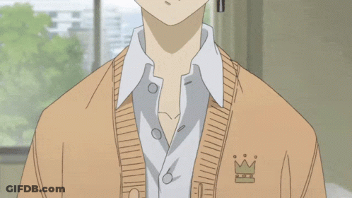 A Boy With A Cross Earring Is Wearing A Tan Sweater GIF
