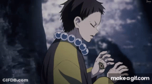 A Boy With A Necklace Around His Neck Is Looking Down At Something .. GIF