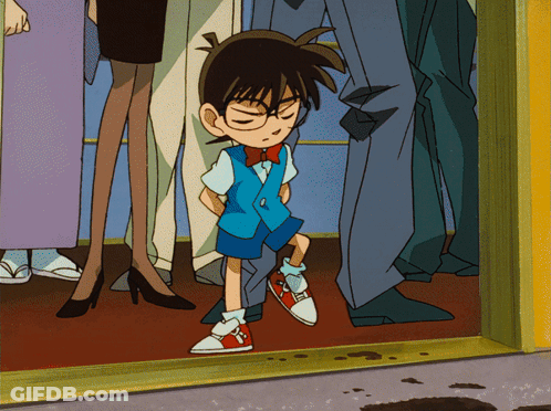 A Boy With Glasses And A Bow Tie Is Standing In A Crowd GIF