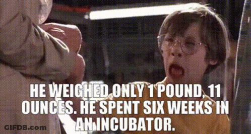 A Boy With Glasses And A Caption That Says He Weighed Only 1 Pound , 11 Ounces . GIF