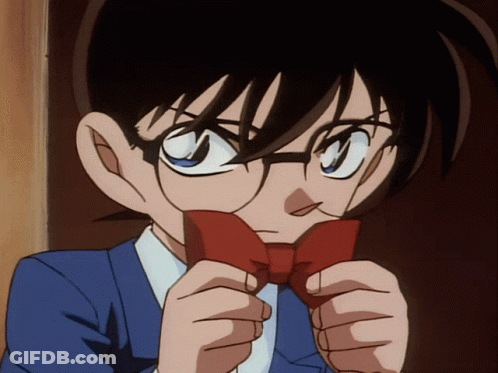 A Boy With Glasses Is Holding A Red Bow Tie In Front Of His Face GIF