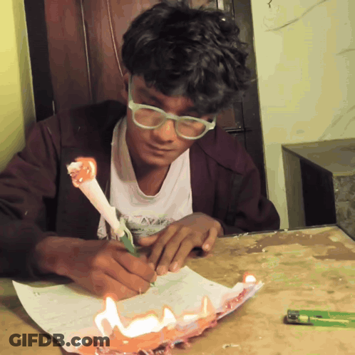 A Boy With Glasses Is Writing On A Piece Of Paper GIF