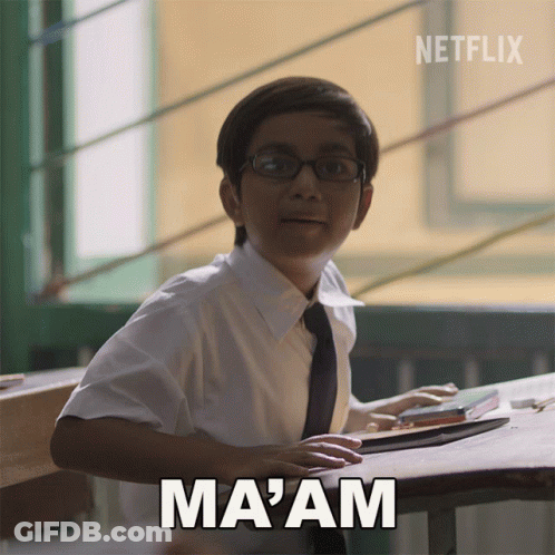 A Boy With Glasses Sits At A Desk With The Word Ma Am Above Him GIF