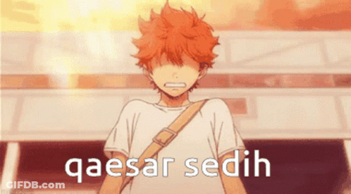 A Boy With Orange Hair Is Standing In Front Of A Building With The Words Qaesar Sedih Written On It GIF