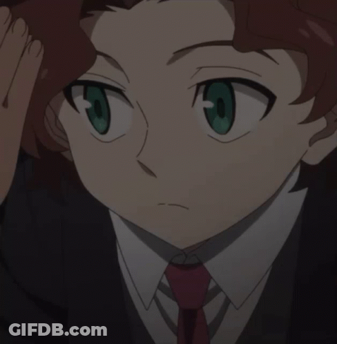 A Boy With Red Hair And Green Eyes Is Wearing A Black Suit And Red Tie GIF