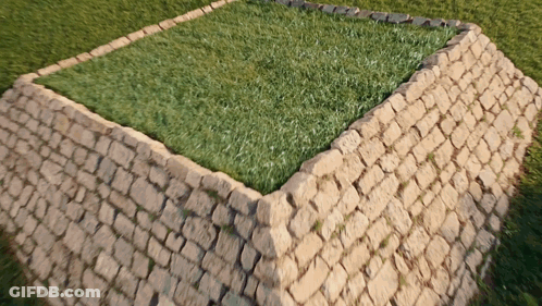A Brick Wall With A Square Of Grass In The Middle GIF
