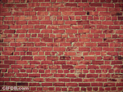 A Brick Wall With Flames Coming Out Of The Center GIF