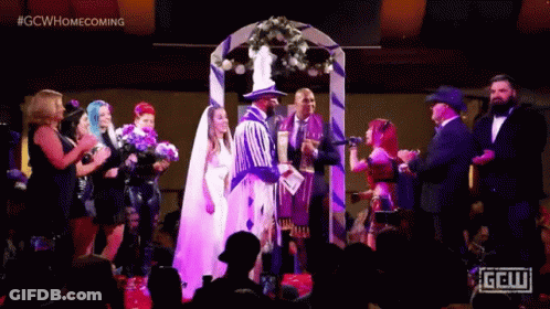 A Bride And Groom Are Getting Married In Front Of A Crowd At A Wedding . GIF