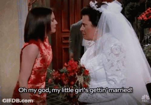 A Bride And Groom Are Standing Next To Each Other And The Bride Is Holding A Bouquet Of Flowers . GIF
