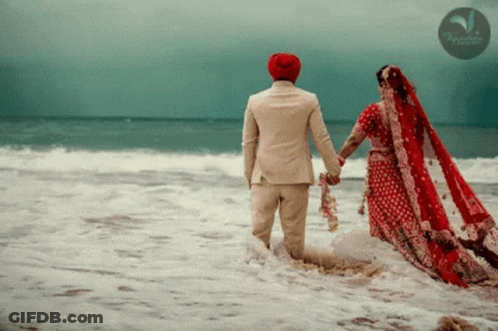 A Bride And Groom Holding Hands In The Ocean With A Watermark That Says ' Tropicana ' On It GIF